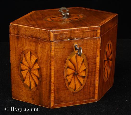 Enlarge Picture: Hexagonal single compartment tea caddy veneered with satinwood and inlaid with marquetry ovals depicting paterae. The top and front have a framing of cross banded kingwood. The caddy retains some of its original leading. 1790